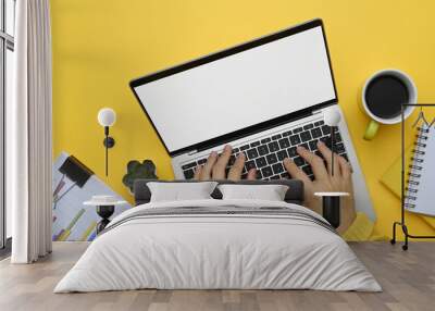 Above view unrecognizable woman hands typing on laptop keyboard over yellow background Wall mural