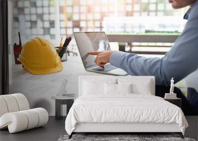 Architect man working on blueprint with engineer planing on office desk. Wall mural