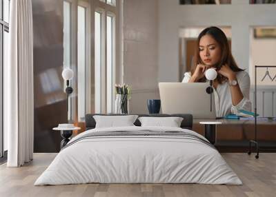 Asian woman working on home office table with thinking moment on laptop. Wall mural