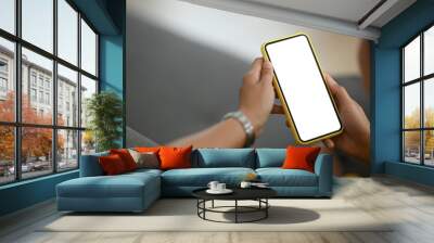 Close up view of woman holding mobile phone with white blank screen that can put any idea and concept in this space. Wall mural