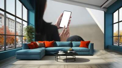 Cropped image of hands are using an empty screen smartphone in the living room. Wall mural