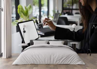 Cropped shot of businesswoman sitting in meeting room and using computer tablet. Wall mural