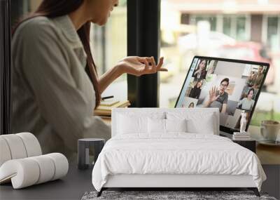 Cropped shot young business woman having online video call on laptop while sitting in modern workplace Wall mural