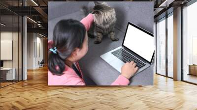 Obese woman using laptop on sofa and caressing her lovely cat. Wall mural