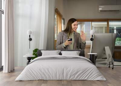 Smiling caucasian businesswoman having video conference on computer monitor, remote working at home Wall mural