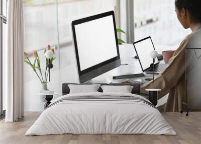 Two screen of computer with businesswoman typing her computer keyboard on modern office desk. Wall mural