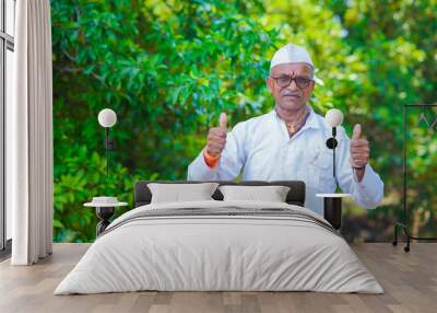 Indian farmer showing thumbs at farm. Wall mural