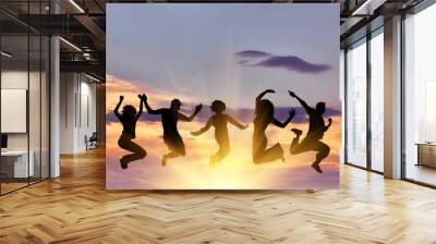  Silhouette of a happy group of people jumping Wall mural