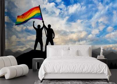 Silhouette of a gay couple with rainbow flag at the top Wall mural