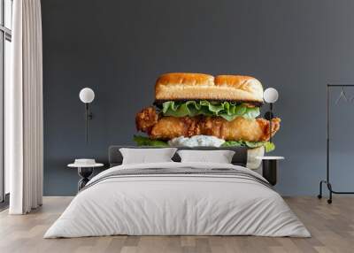 A high-end food photograph of a fish sandwich with lettuce, tartar sauce, and a toasted bun, placed on a solid background. The sandwich is fully in focus with deep depth of field, offering space for Wall mural