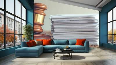 A gavel rests beside a neat stack of legal documents, symbolizing justice, law, and courtroom proceedings in a professional setting. Wall mural