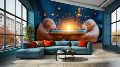 A person holding a smartphone with bright sparks emanating from the screen, symbolizing technology and innovation. Wall mural