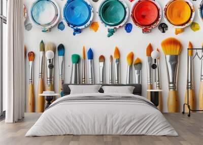 Closeup of a collection of art supplies including brushes, paints, and sketching tools, arranged creatively, isolated on a white background with ample space for text Wall mural