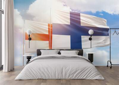 Sunny blue sky and flags of finland and england Wall mural