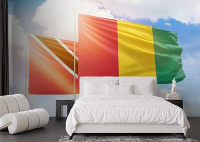 Sunny blue sky and flags of guinea and trinidad and tobago Wall mural