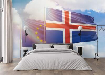 Sunny blue sky and flags of iceland and european union Wall mural