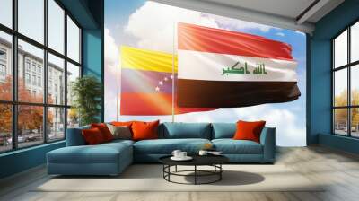 Sunny blue sky and flags of iraq and venezuela Wall mural