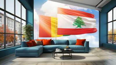 Sunny blue sky and flags of lebanon and guinea Wall mural