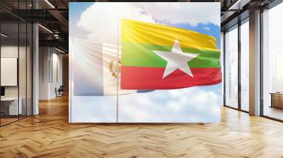 Sunny blue sky and flags of myanmar and guatemala Wall mural