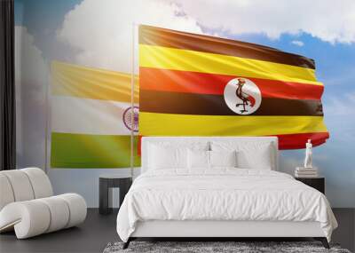 Sunny blue sky and flags of uganda and india Wall mural