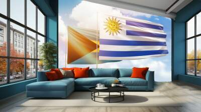 Sunny blue sky and flags of uruguay and bahamas Wall mural