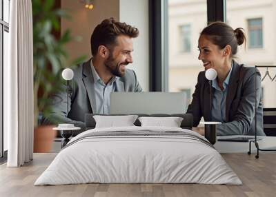 Happy professional business man and woman working on laptop at office meeting, two busy colleagues working together having conversation on project, discussing business plan at office  Wall mural