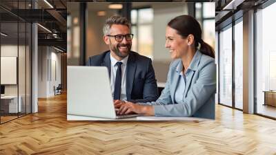 Happy professional business man and woman working on laptop at office meeting, two busy colleagues working together having conversation on project, discussing business plan at office  Wall mural