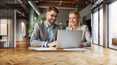 Happy professional business man and woman working on laptop at office meeting, two busy colleagues working together having conversation on project, discussing business plan at office  Wall mural