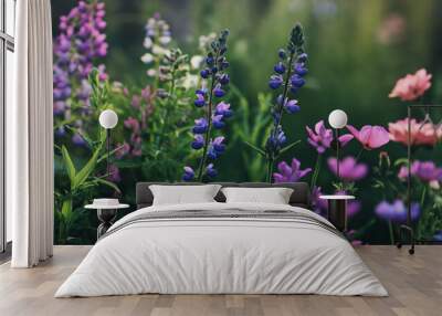 A field of blue, purple, and pink wildflowers bloom in the summer sun. Wall mural