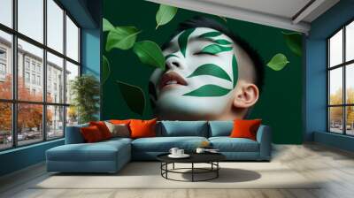 A young man with green face paint surrounded by leaves. Wall mural