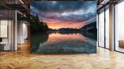 Sunset over the alpine lake Wolfgangsee with storm clouds and an alpine village in the background. This beautiful scenery is mirrored on the surface of the lake. Wall mural