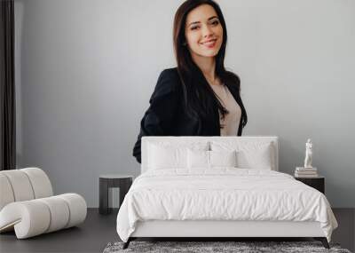 Young attractive emotional girl in business-style clothes on a plain white background in an office or audience Wall mural