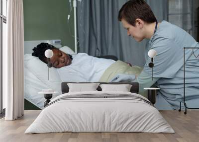 African American patient resting in hospital bed while medical professional examining and providing care. Patient appears relaxed and comfortable during the procedure Wall mural