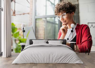 busy young elegant woman in eyeglasses looking at laptop display Wall mural