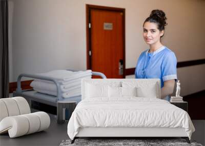 Chamber maid pulling cart with clean towels while moving along corridor in hotel Wall mural