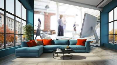 close-up of modern table with computer on it and business people working in the background Wall mural