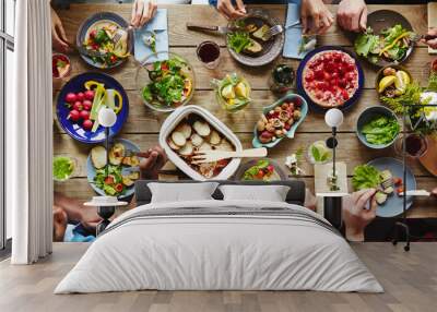 Friendly humans eating tasty dinner by festive table Wall mural