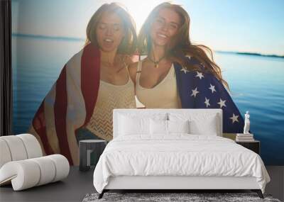 Happy girls wrapped in American flag celebrating Independence Day Wall mural