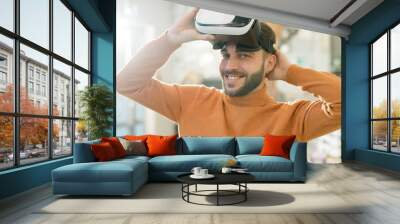 Happy young man looking at you with smile while taking off vr headset Wall mural