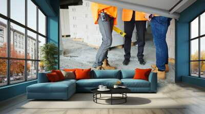 low section shot of legs of two construction workers wearing jeans and brown leather work boots stan Wall mural