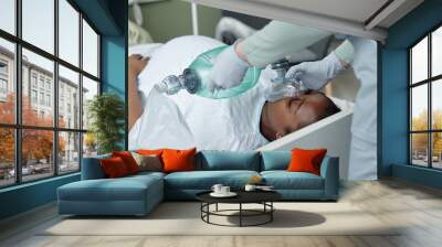 Medical professional giving emergency assistance with oxygen mask in hospital room demonstrating essential care during critical condition demonstrating urgency and medical aid procedure Wall mural