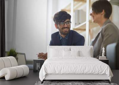 modern middle eastern man wearing creative haircut and glasses communicating with his colleague in m Wall mural