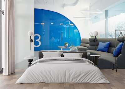 Modern office with cozy lobby furnished with sofa and coffee tables, interior with blue elements Wall mural