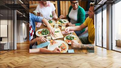 One of guys taking slice of pizza from plate while talking to his buddy by dinner Wall mural