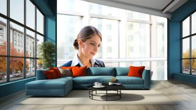 portrait of business woman sitting at the table and typing Wall mural