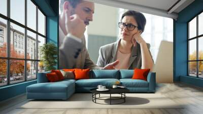 portrait of two confused business people, man and woman, solving work problem during meeting in cafe Wall mural