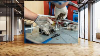 Repairman fixing bolt in the center of bicycle wheel Wall mural