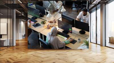 Several co-workers looking at information on computer screens in office Wall mural