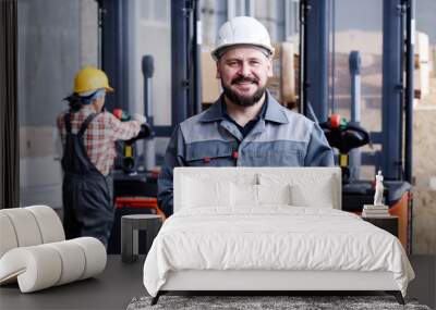 Successful mature male picker or quality control manager with tablet standing in front of camera against his female coworker Wall mural