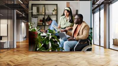 Team working together with focus on collaboration and inclusivity, featuring colleagues showing interaction and productivity in contemporary office with natural light Wall mural